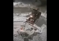 Трактор собирает снег под окнами