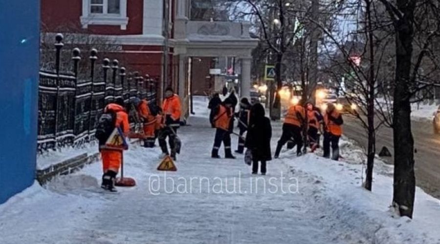 Десяток работников убирают снег возле здания Думы
