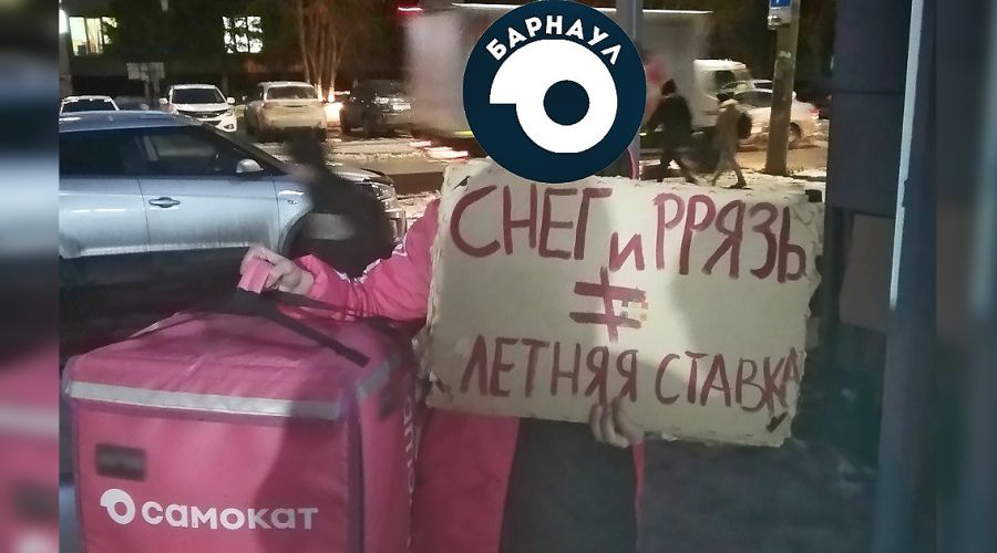Барнаульский сотрудник сервиса держит плакат с требованиями к работодателю