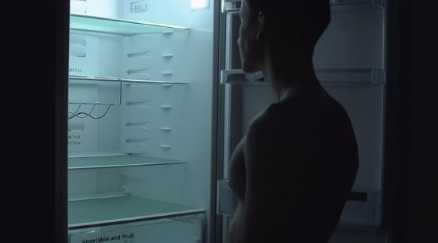 Женщина открывает холодильник