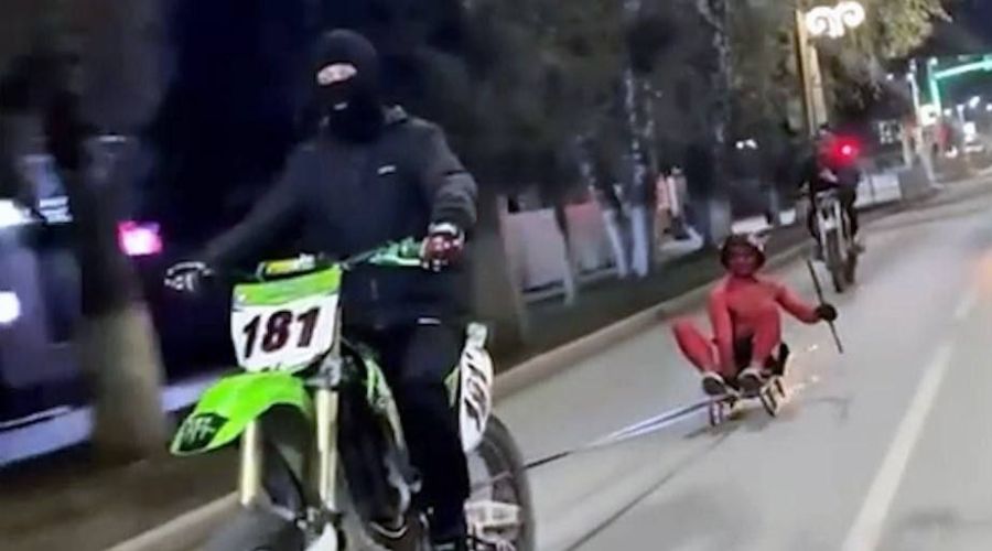 Мотоциклист везет участника челленджа от Мелстроя