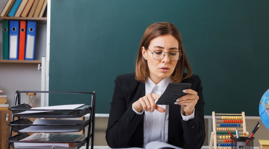 Учительница считает что-то на калькуляторе